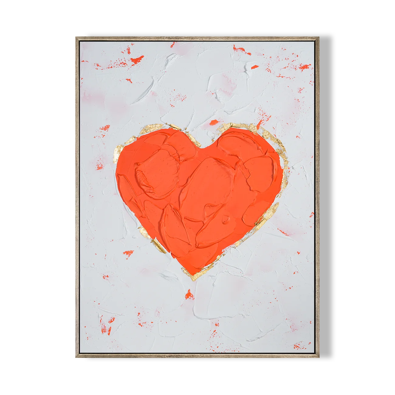 Framed abstract artwork with a red heart on a white wall above a beige sofa.