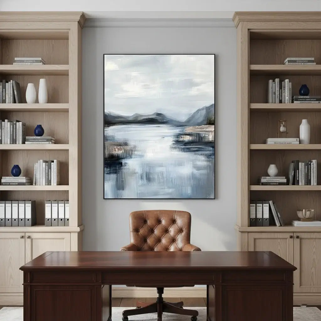 Home office with wooden desk, leather chair, bookshelves, and abstract landscape painting.