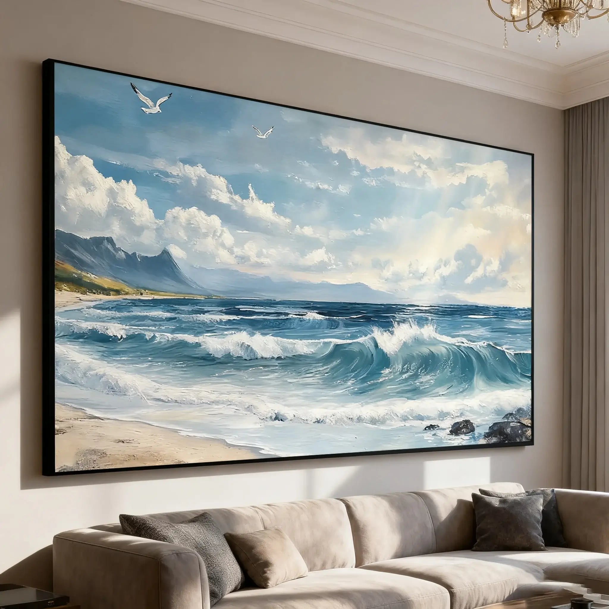 Large framed painting of a beach scene with waves and mountains in a living room.