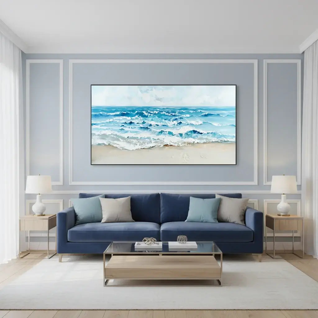 Living room with a blue sofa, coffee table, and wall art of a beach scene.