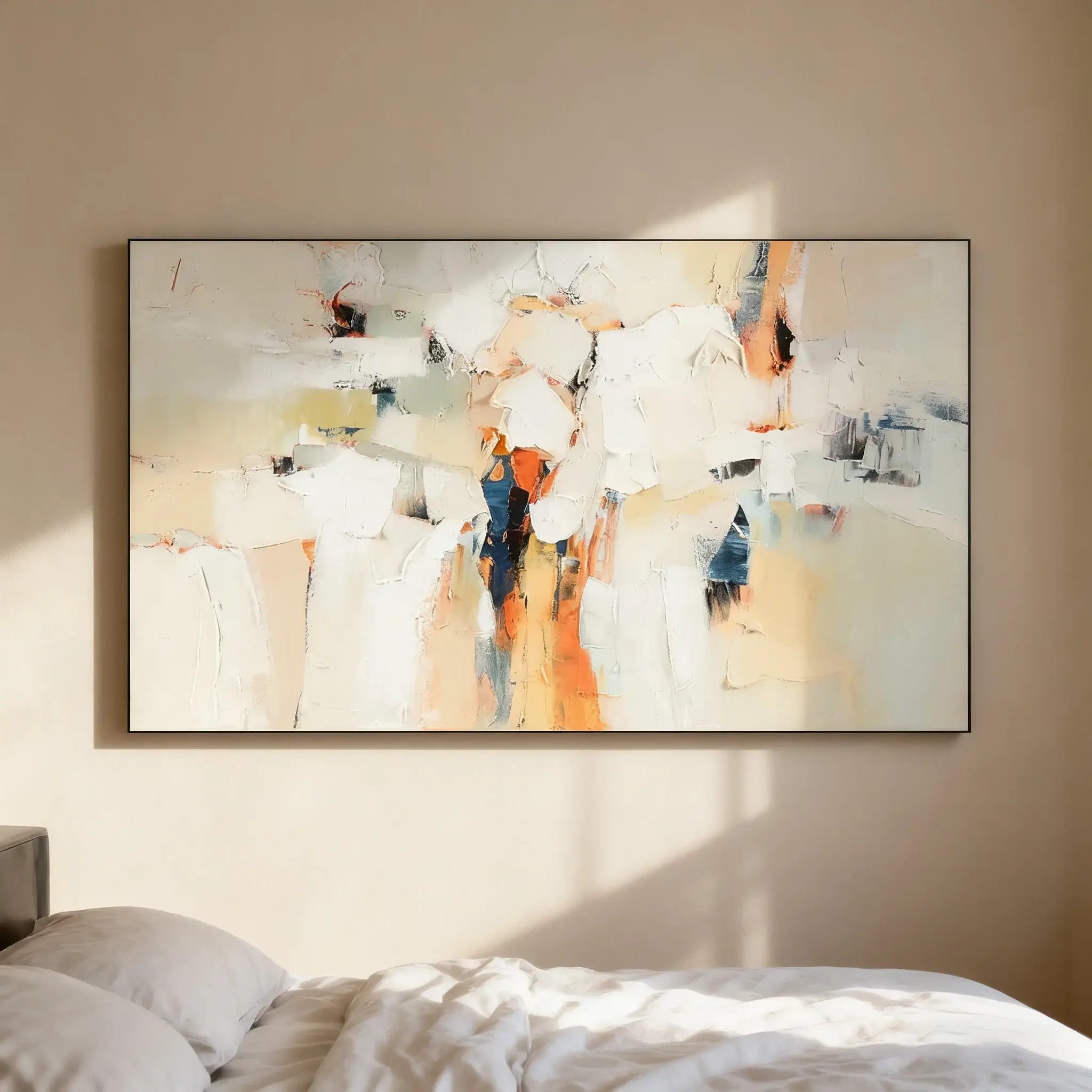 Abstract art painting on a wall in a room with bedding.