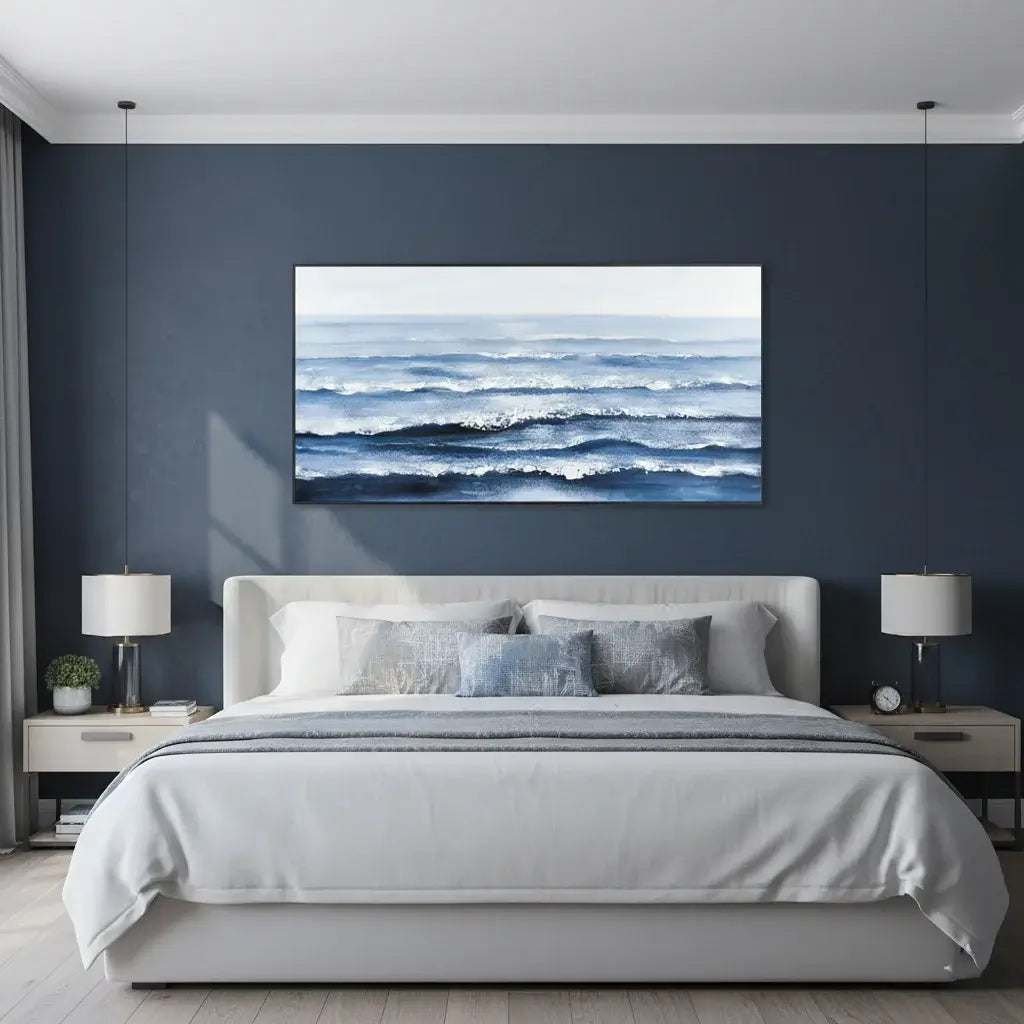 Modern bedroom with a large ocean painting on the wall above a bed.