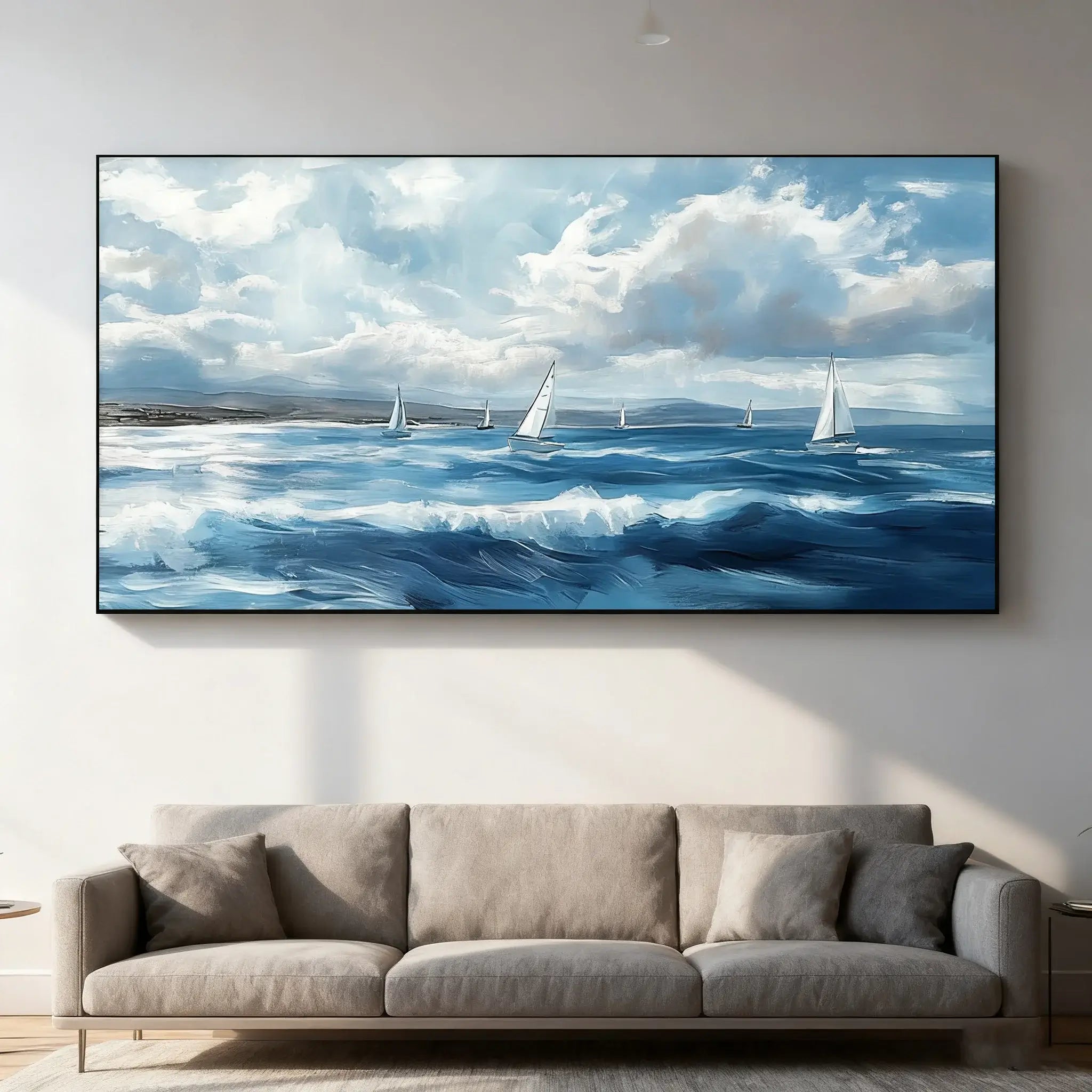 Large wall-mounted painting of sailboats on a blue sky and ocean scene above a gray sofa.