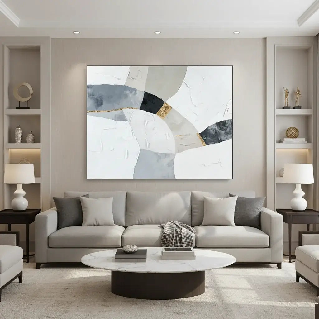 Modern living room with a gray sofa, round coffee table, and abstract painting on the wall.