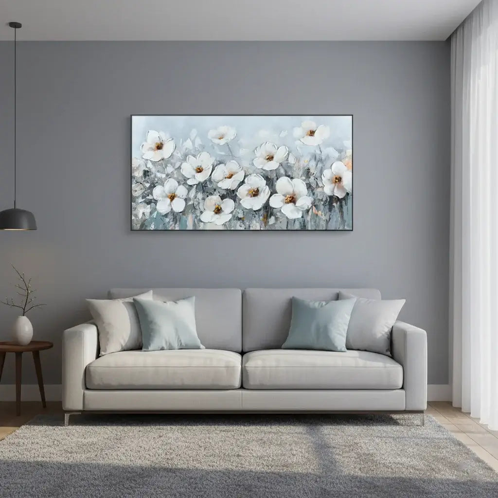 Gray sofa with decorative pillows in a living room with a floral painting on the wall.