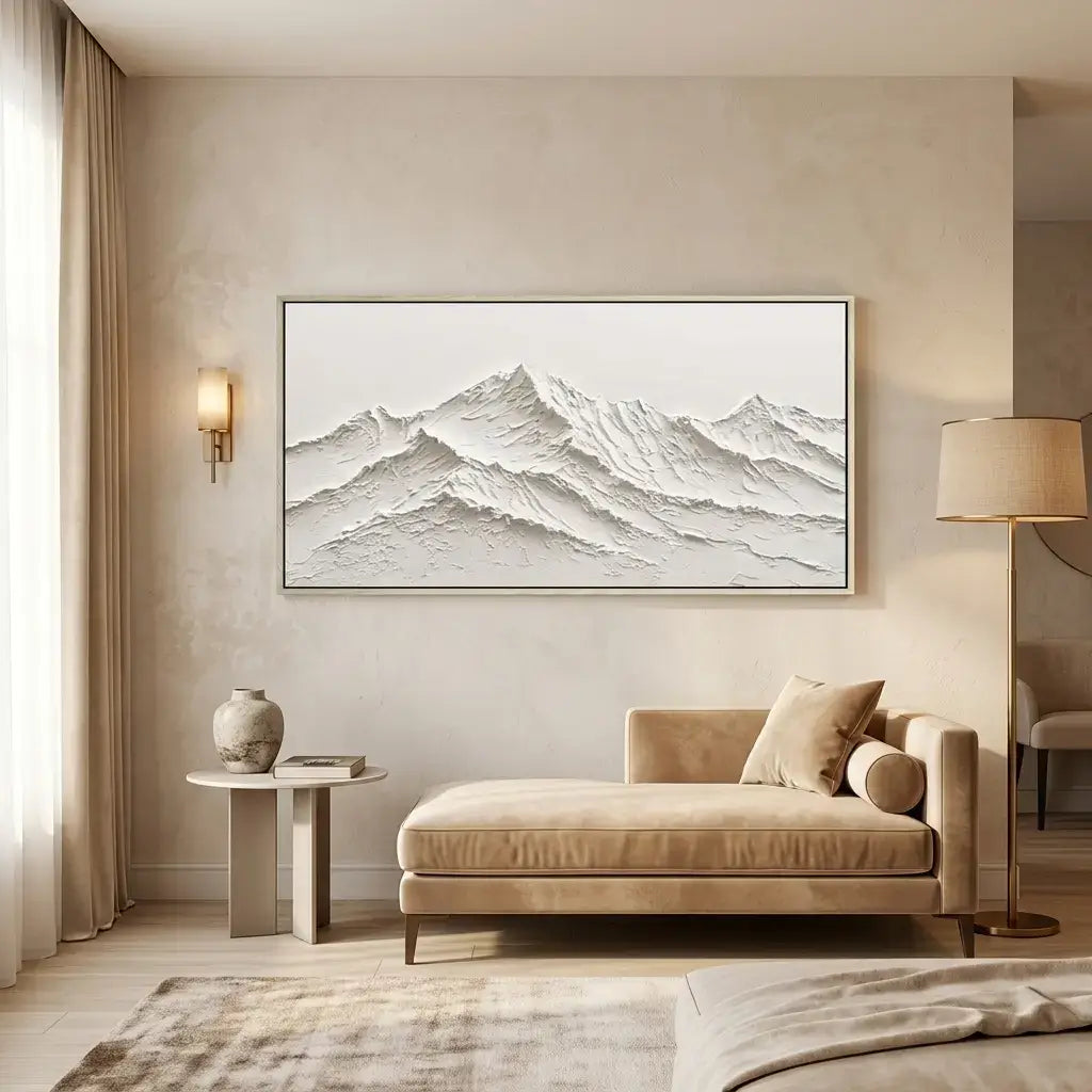 Modern living room with a beige sofa, side table, and framed mountain landscape on the wall.