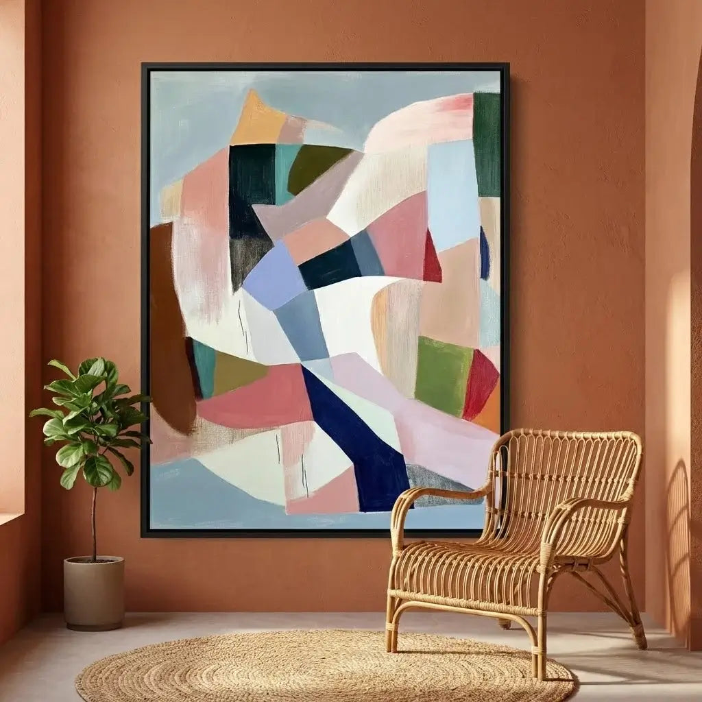 Abstract art piece on a wall with a wicker chair and plant in a room.