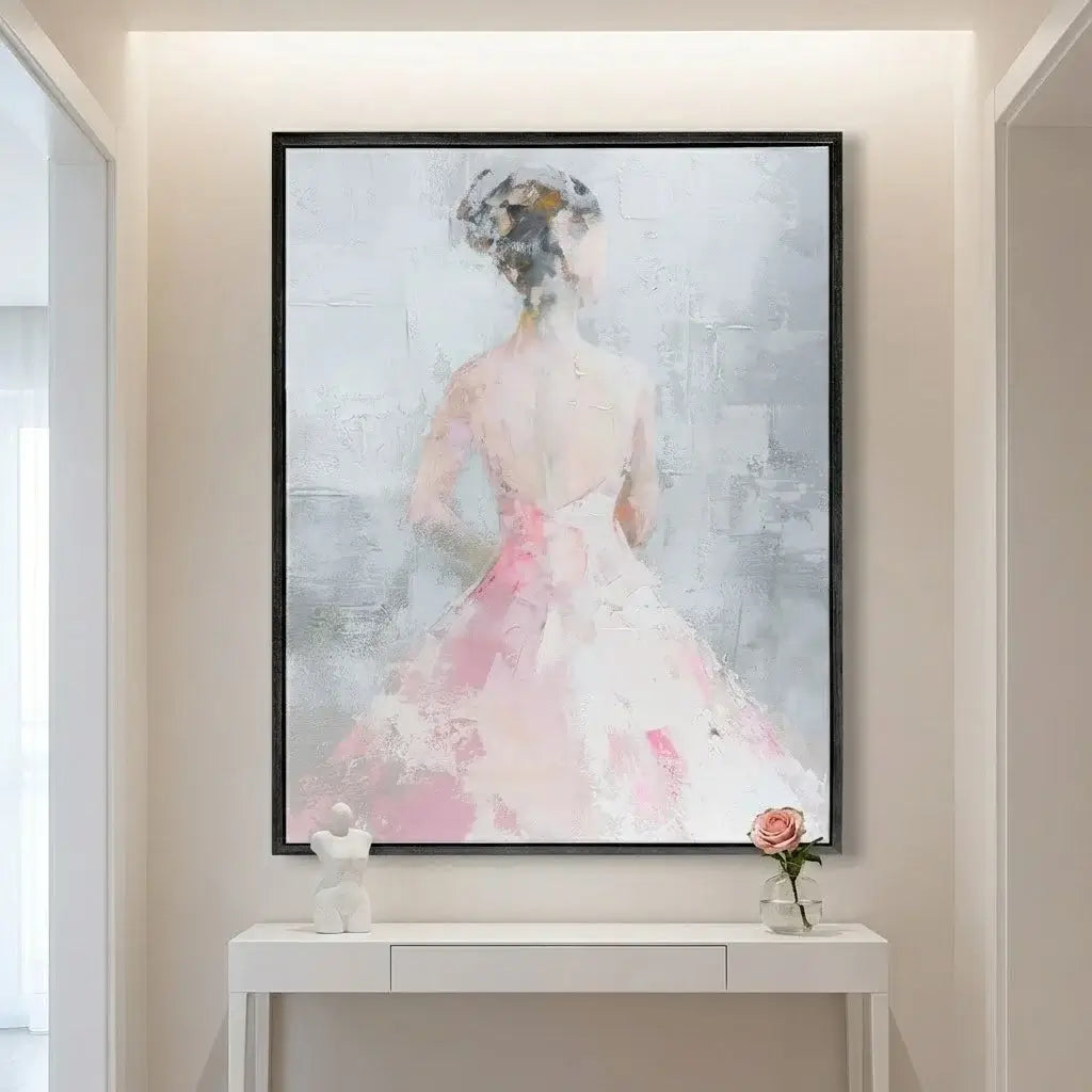 Framed artwork of a woman in a pink dress on a wall above a white console table.