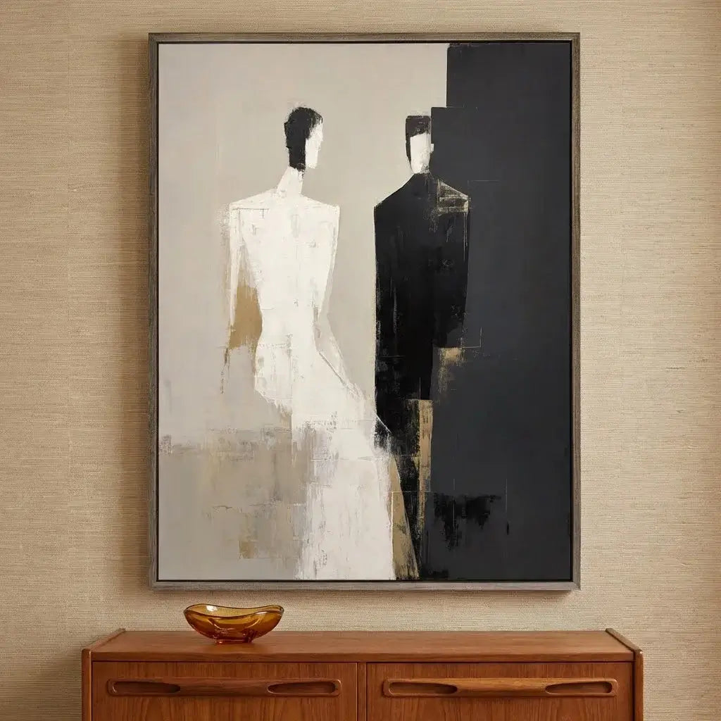 Abstract painting of two figures on a wall above a wooden cabinet.