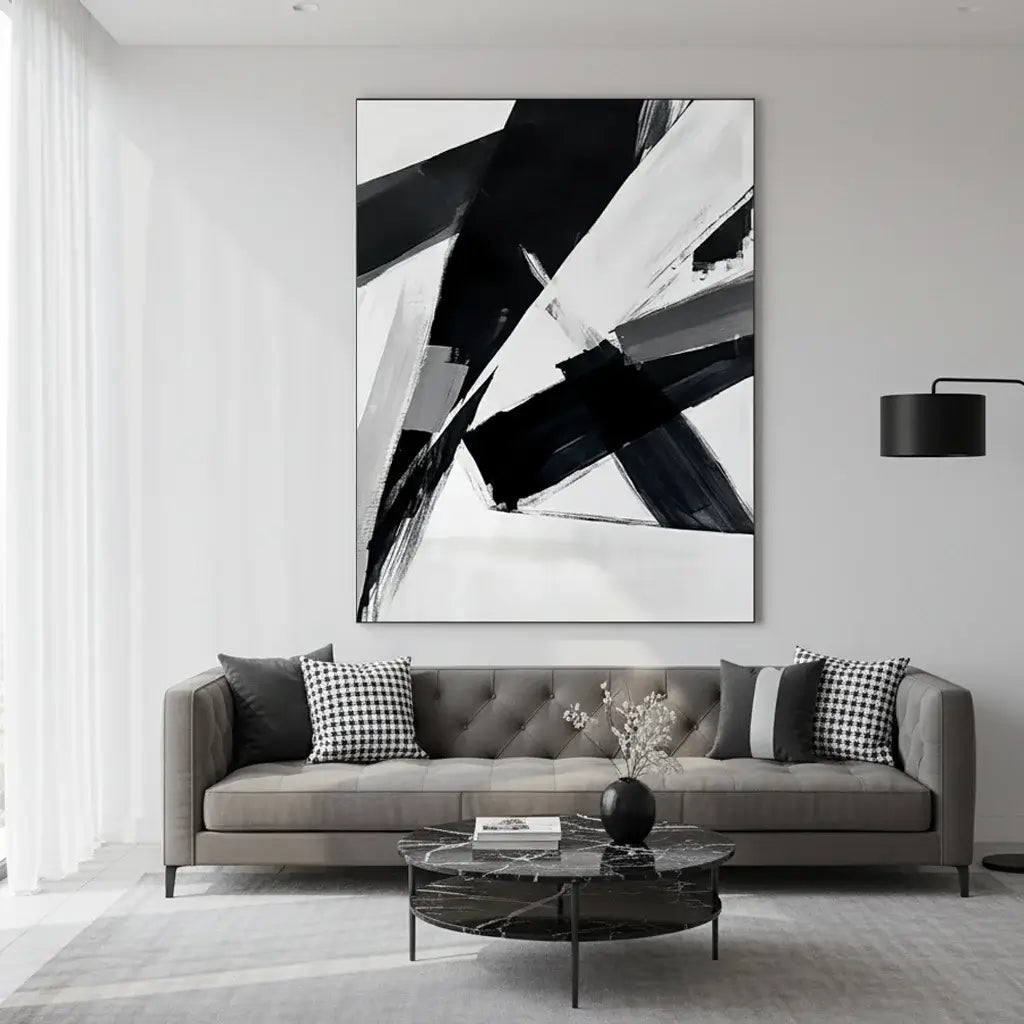 Modern living room with abstract black and white artwork on the wall above a gray sofa.