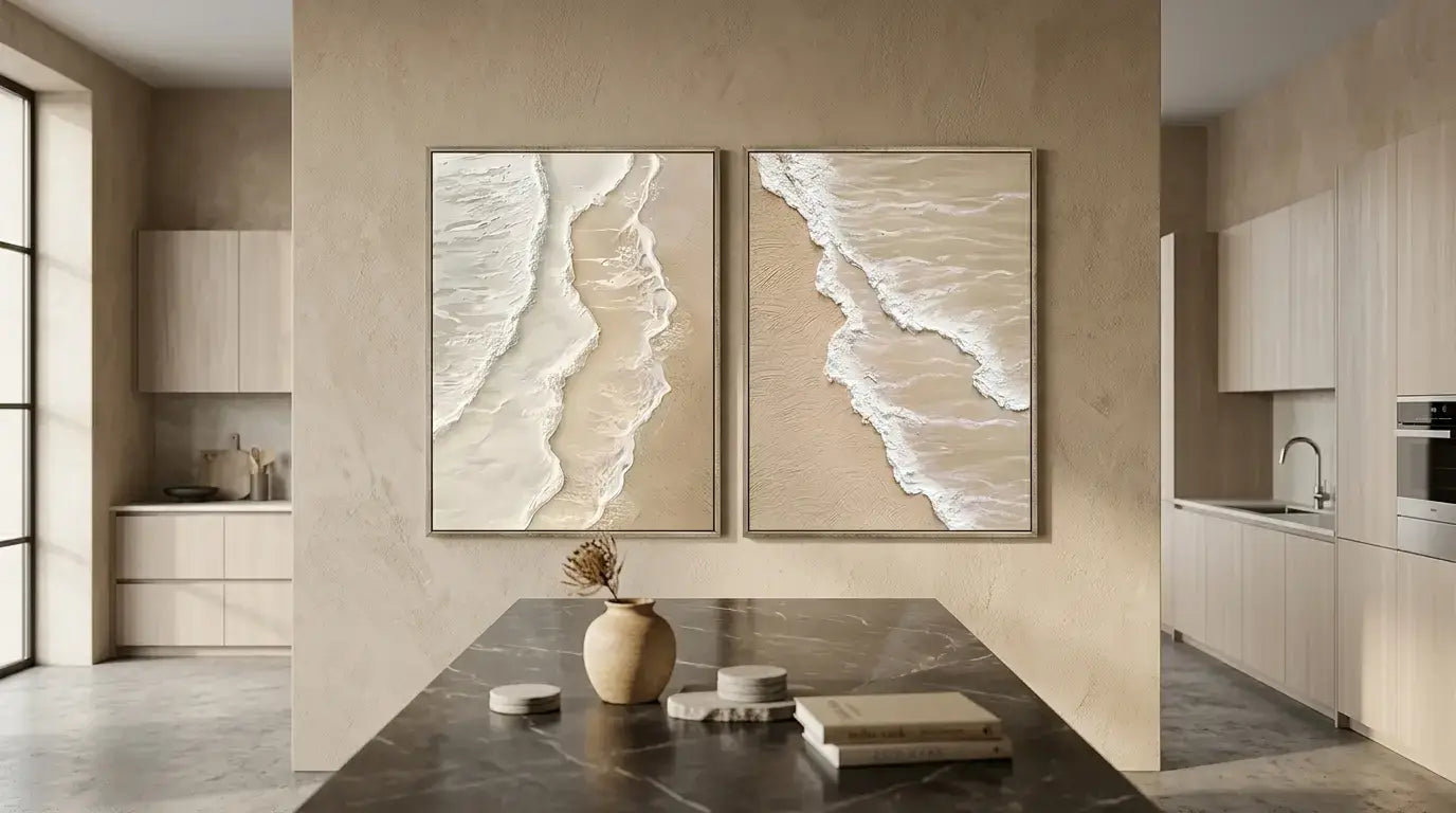 Two framed beachscape artworks on a wall in a modern kitchen.