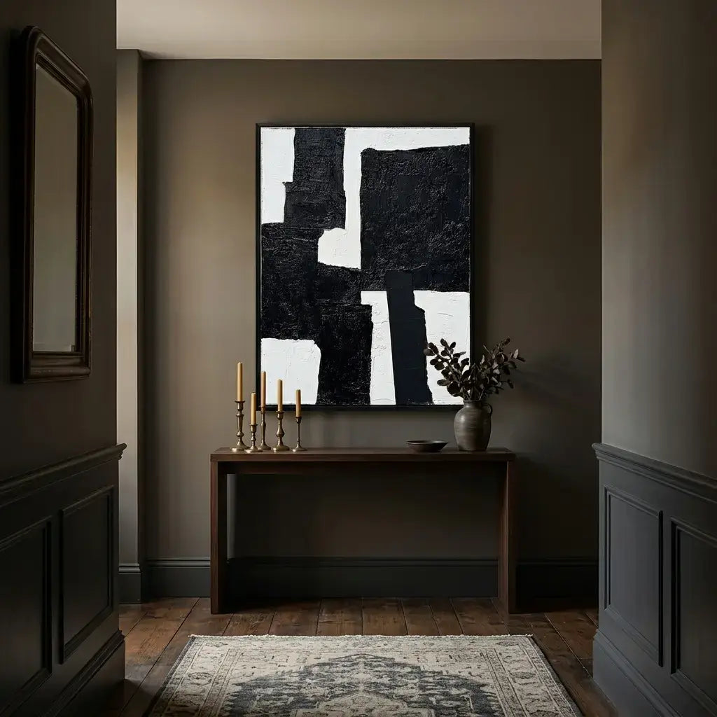 Modern interior with abstract art, candles, and a vase on a dark wall.