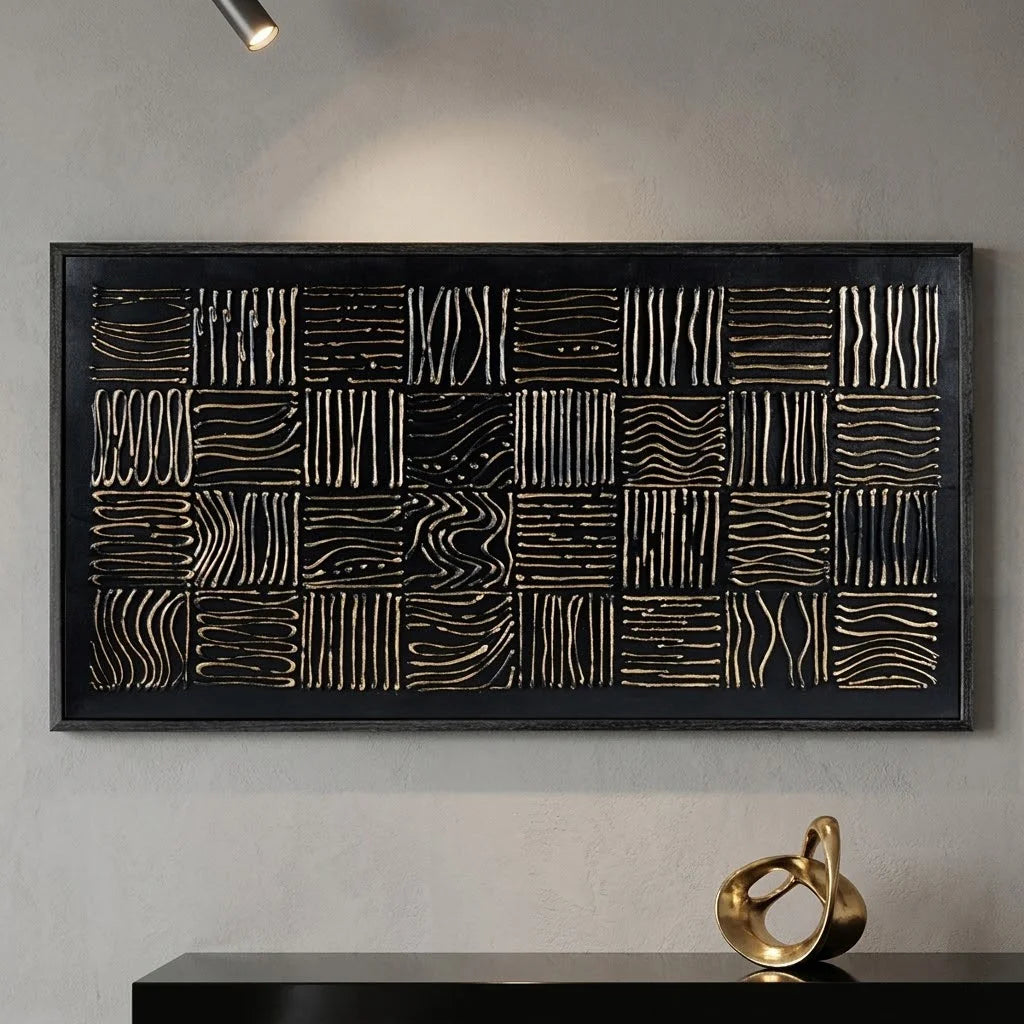 Decorative wall art with geometric pattern on a gray wall, next to a vase with dried plant leaves.