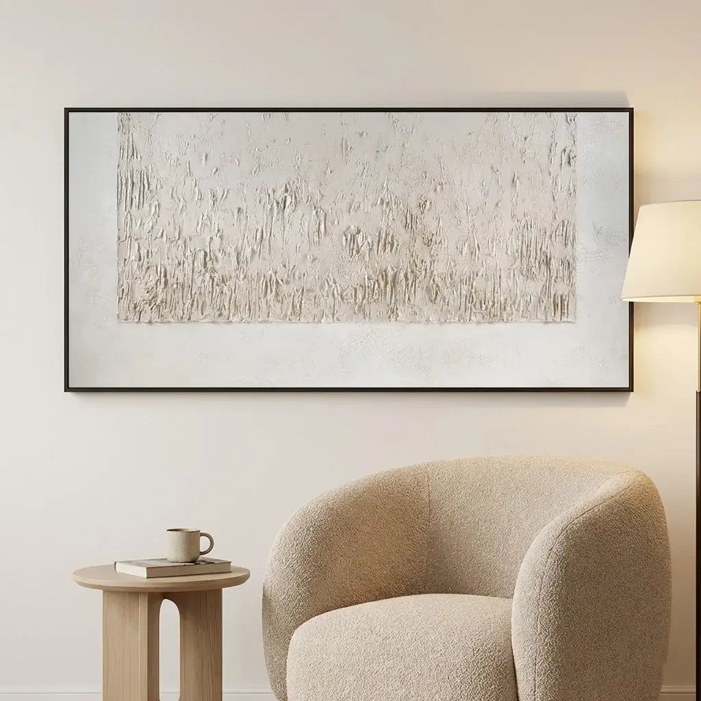 Beige armchair in a room with a large abstract painting on the wall.