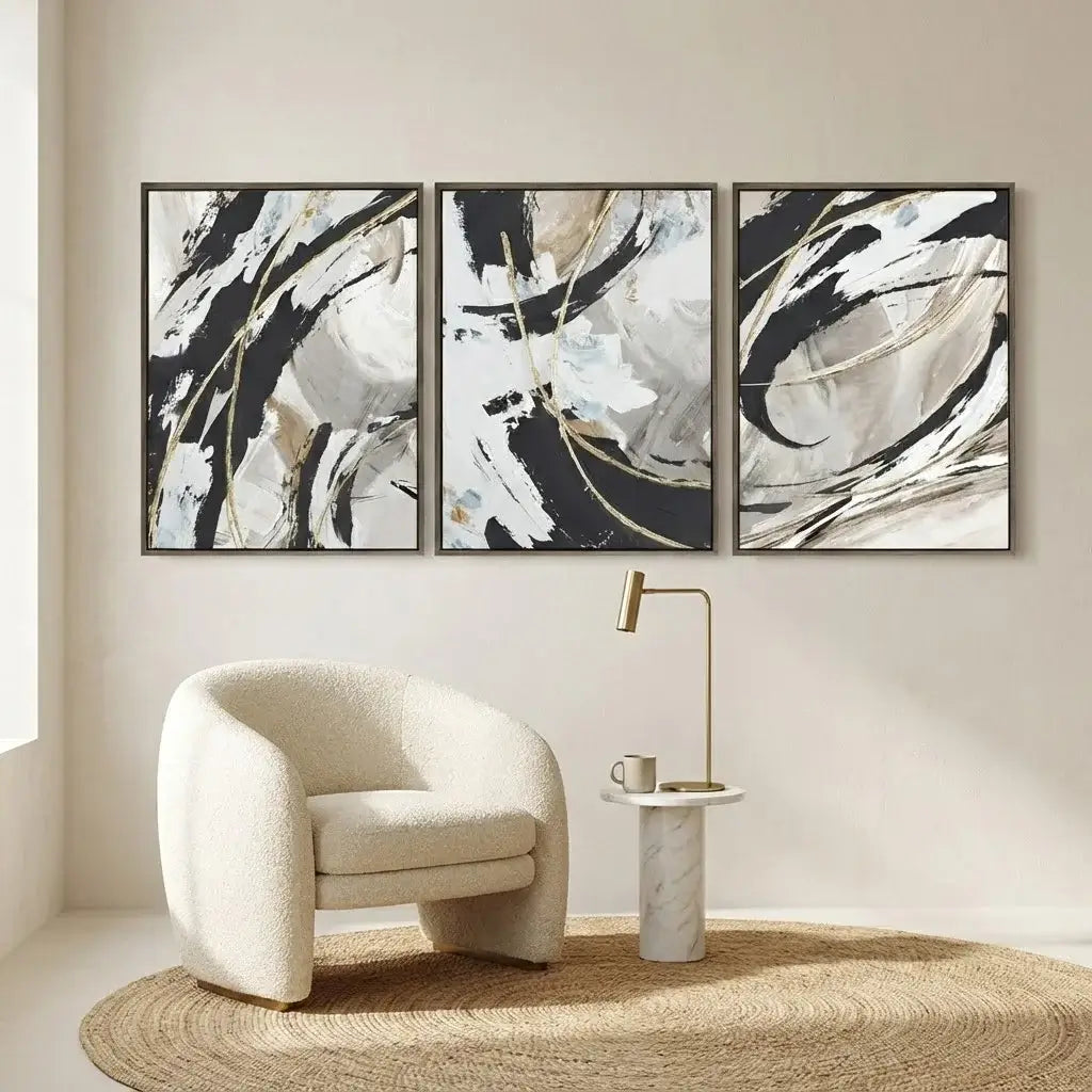 Abstract art triptych on a wall with a modern chair and side table.