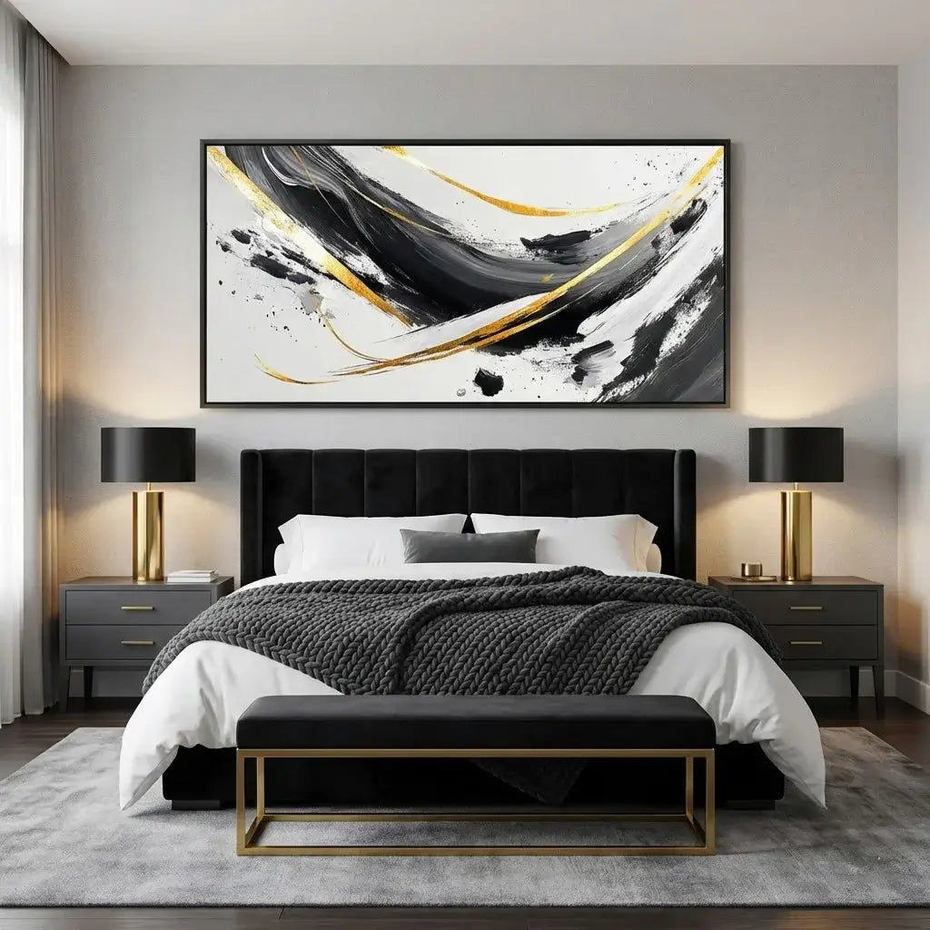 Modern bedroom with a black upholstered bed, abstract art on the wall, and two lamps.