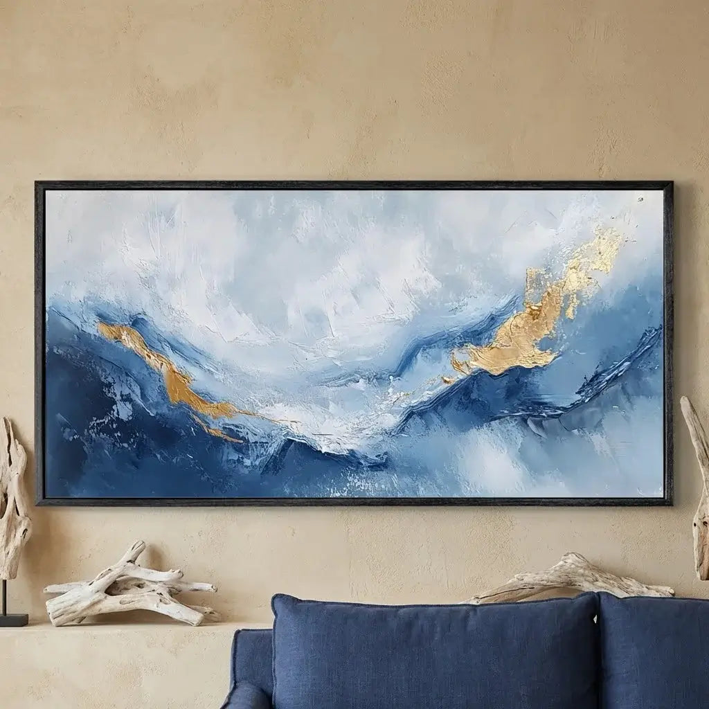 Abstract painting with blue and gold tones on a beige wall above a blue sofa.
