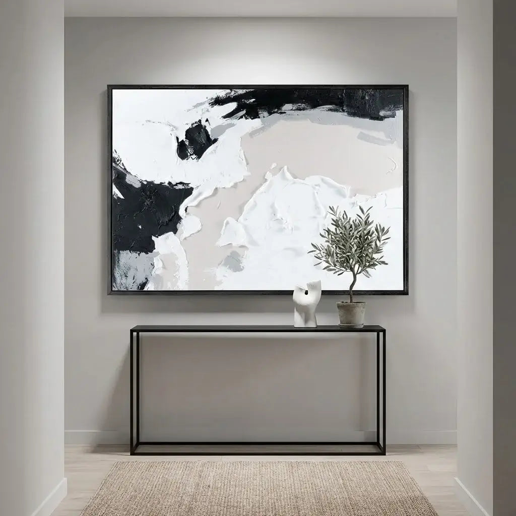 Abstract art piece on a wall above a console table with decorative items.