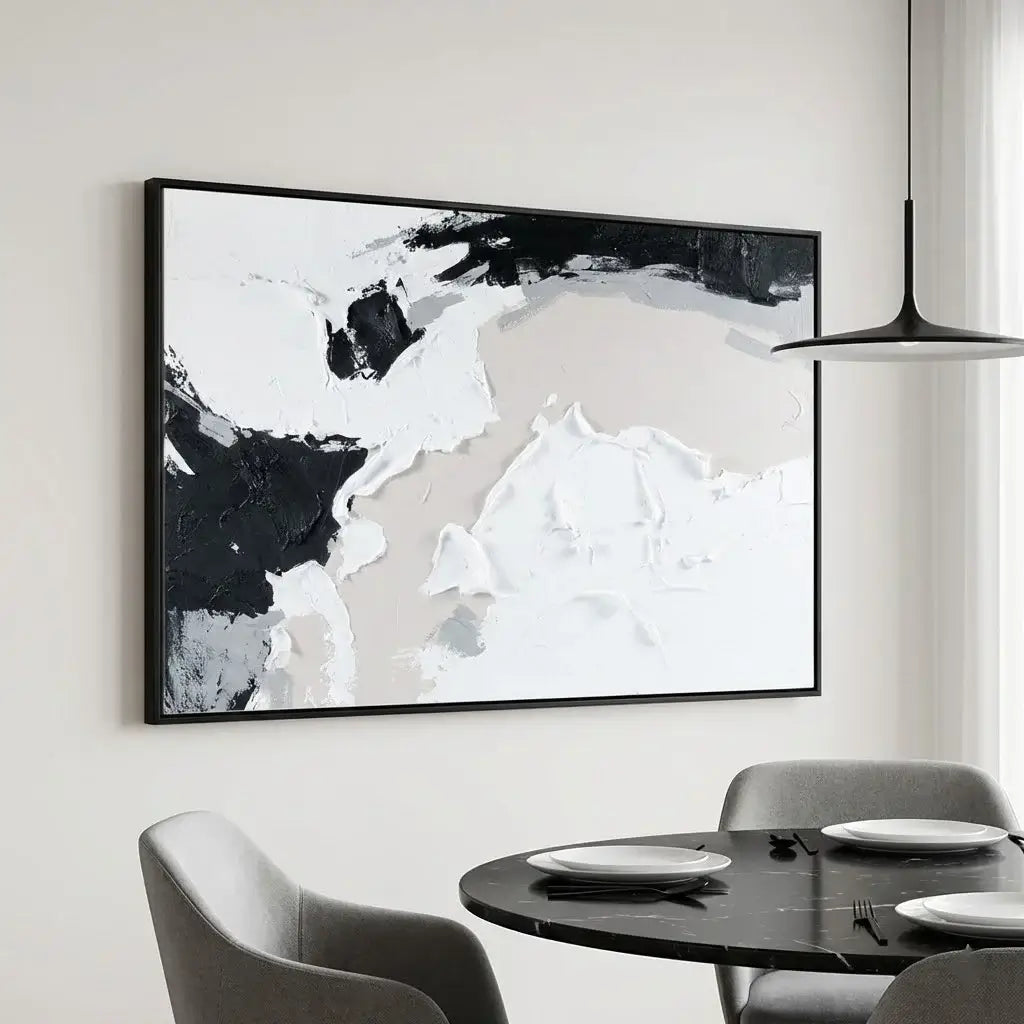 Abstract black and white painting on a wall above a dining table with chairs.
