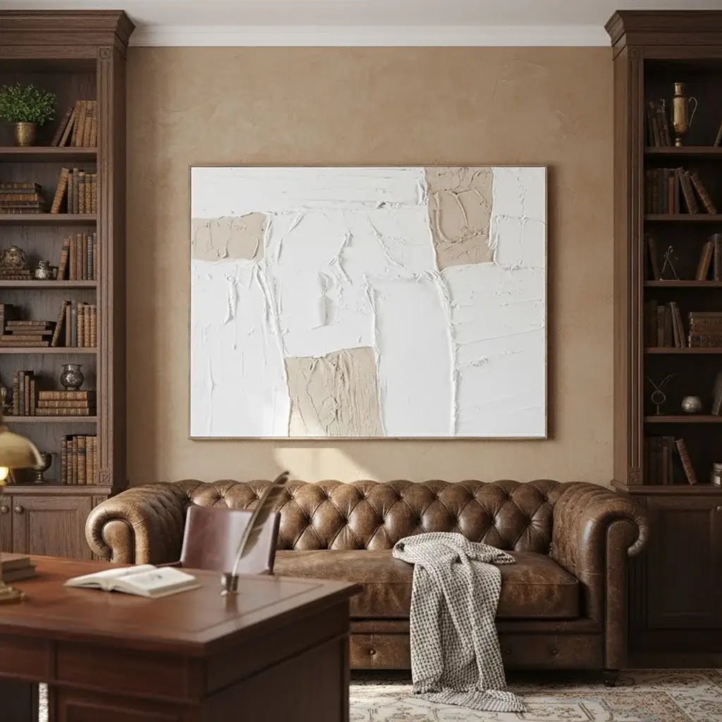 Living room with brown leather sofa, wooden bookshelves, and abstract painting on beige wall.