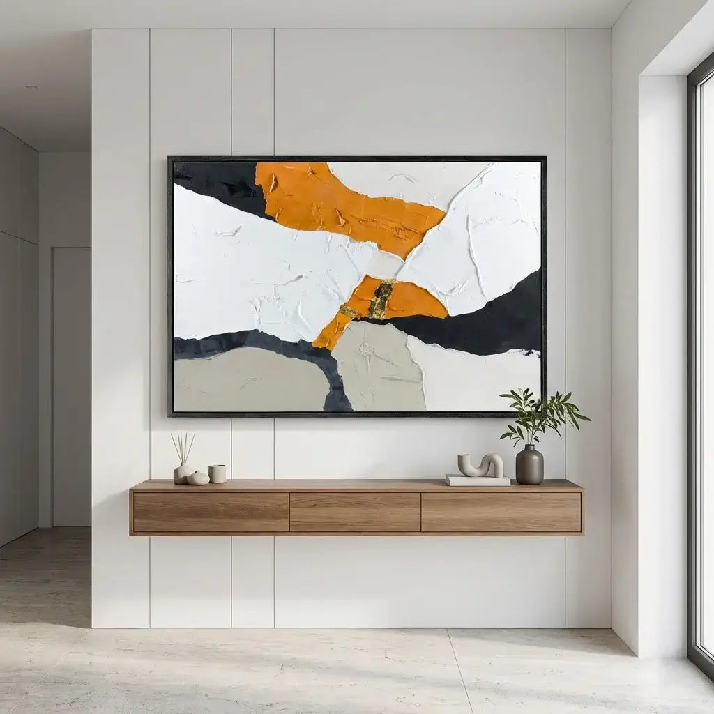 Abstract art piece on a wall above a wooden console table in a modern interior.