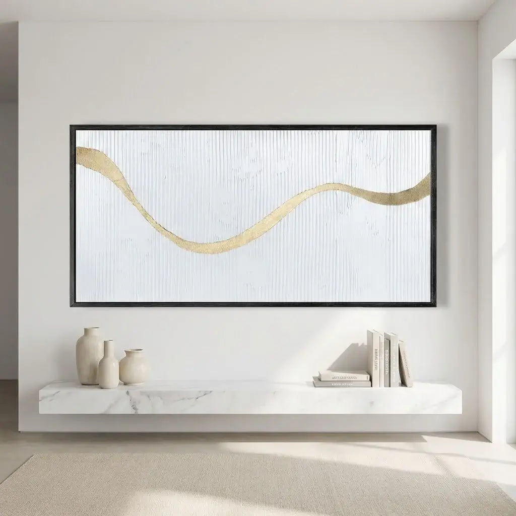Abstract artwork with a gold wave design on a white wall above a marble shelf.