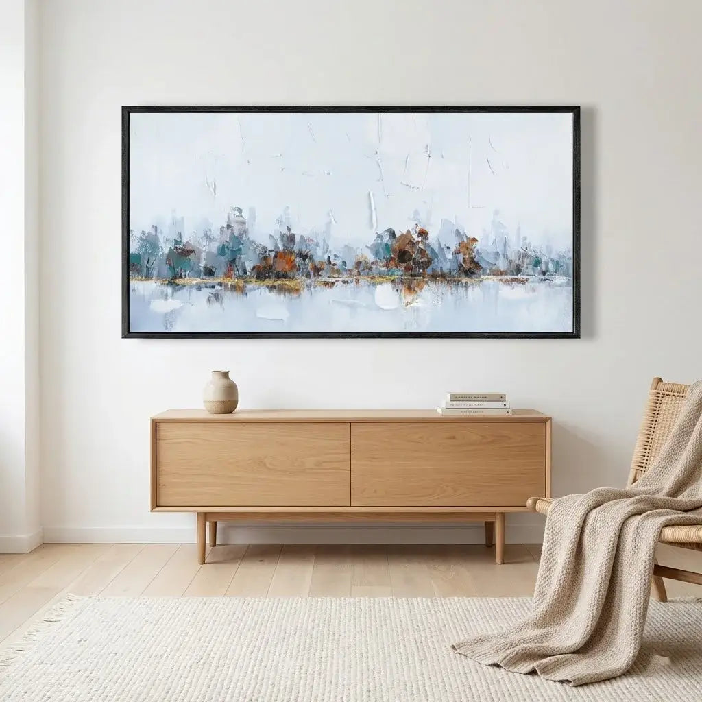 Framed abstract artwork on a wall above a wooden console table in a living room.