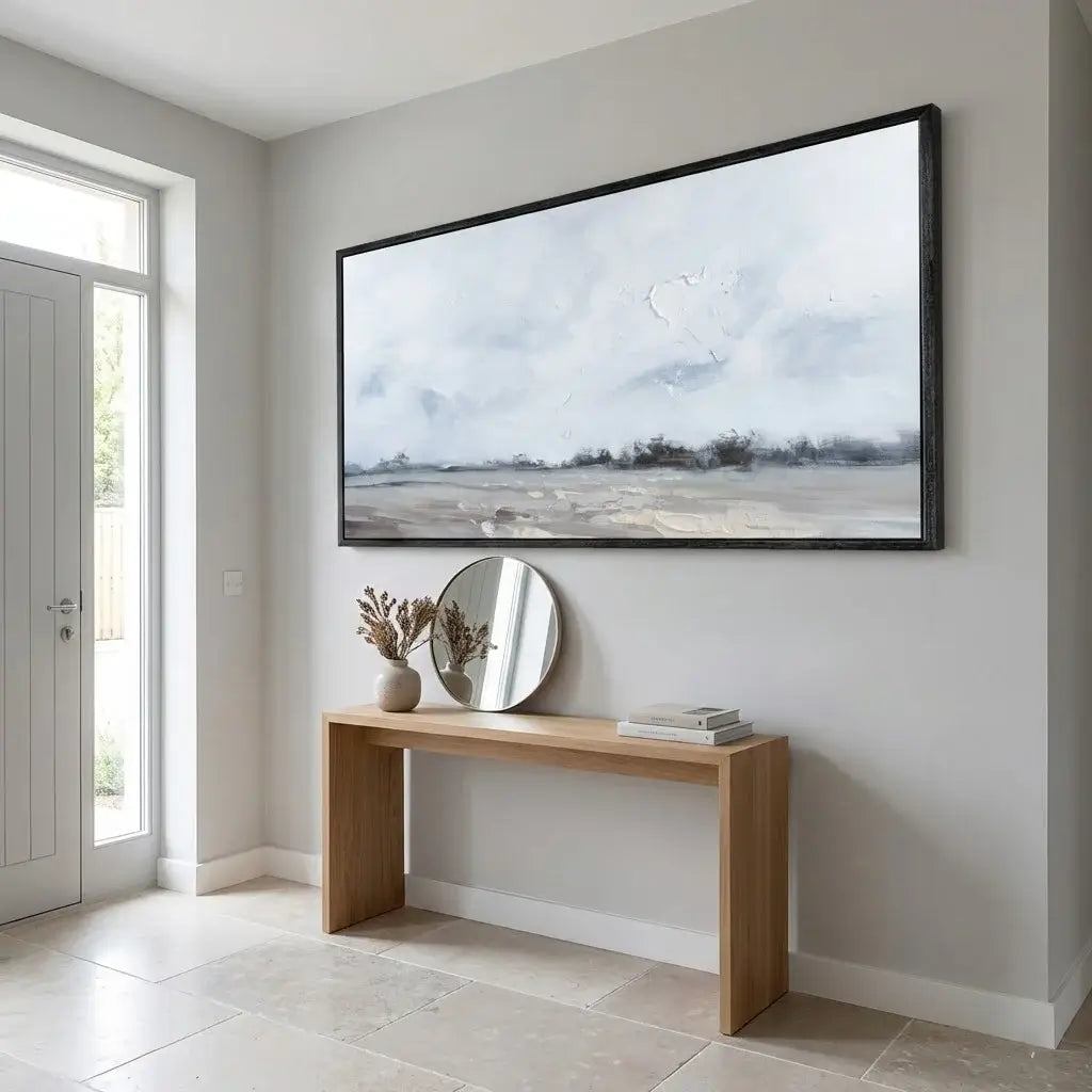 Modern interior with a large framed picture on the wall above a wooden console table.