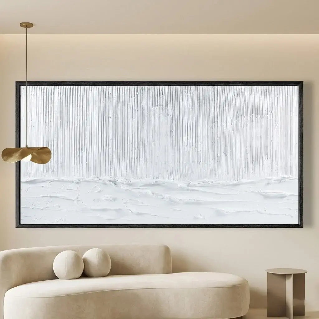 Abstract art piece on a wall above a modern sofa with a gold pendant light.