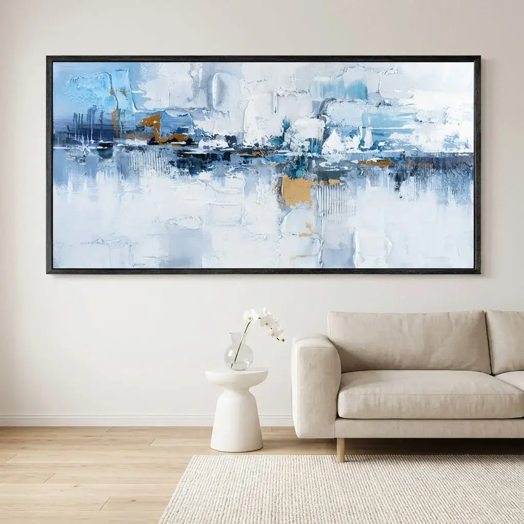 Abstract painting in a modern living room with a beige sofa and white side table.