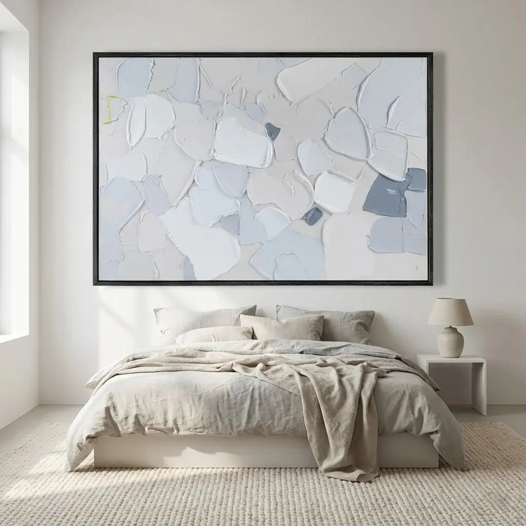 Abstract art piece on a wall above a bed in a bedroom