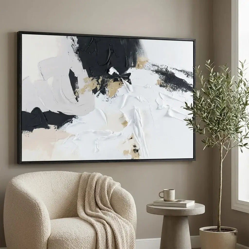 Abstract art piece on a wall above a beige armchair with a plant and small table in the foreground.