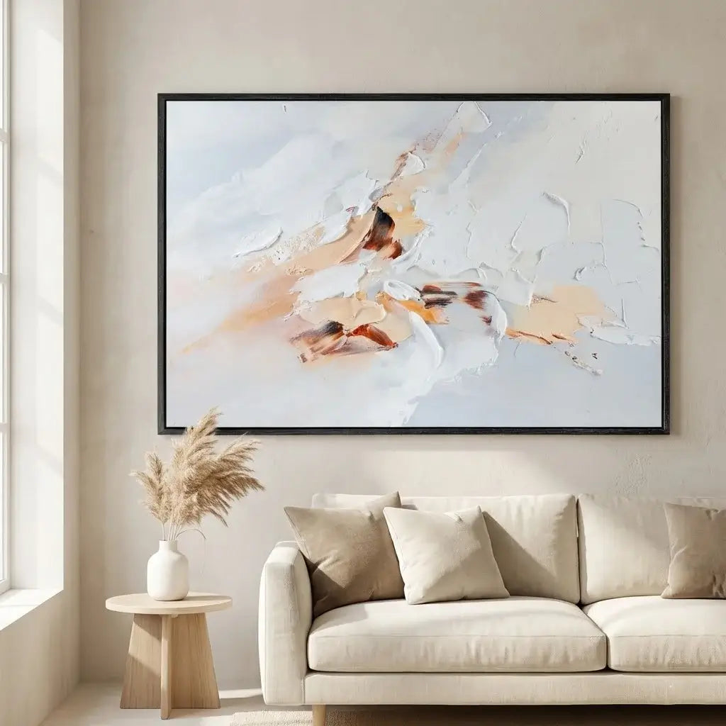 Framed abstract painting on a wall above a beige sofa in a living room.