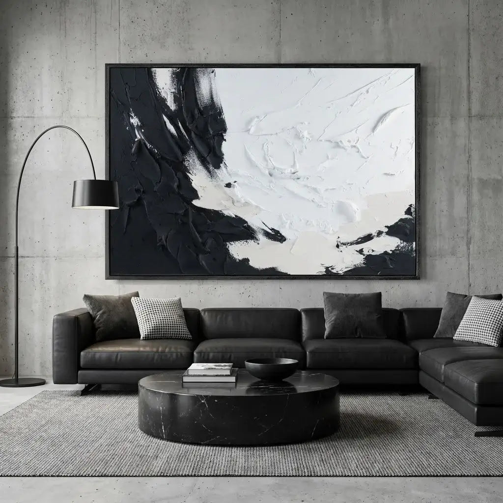 Modern living room with a black leather sofa, abstract art, and marble coffee table.