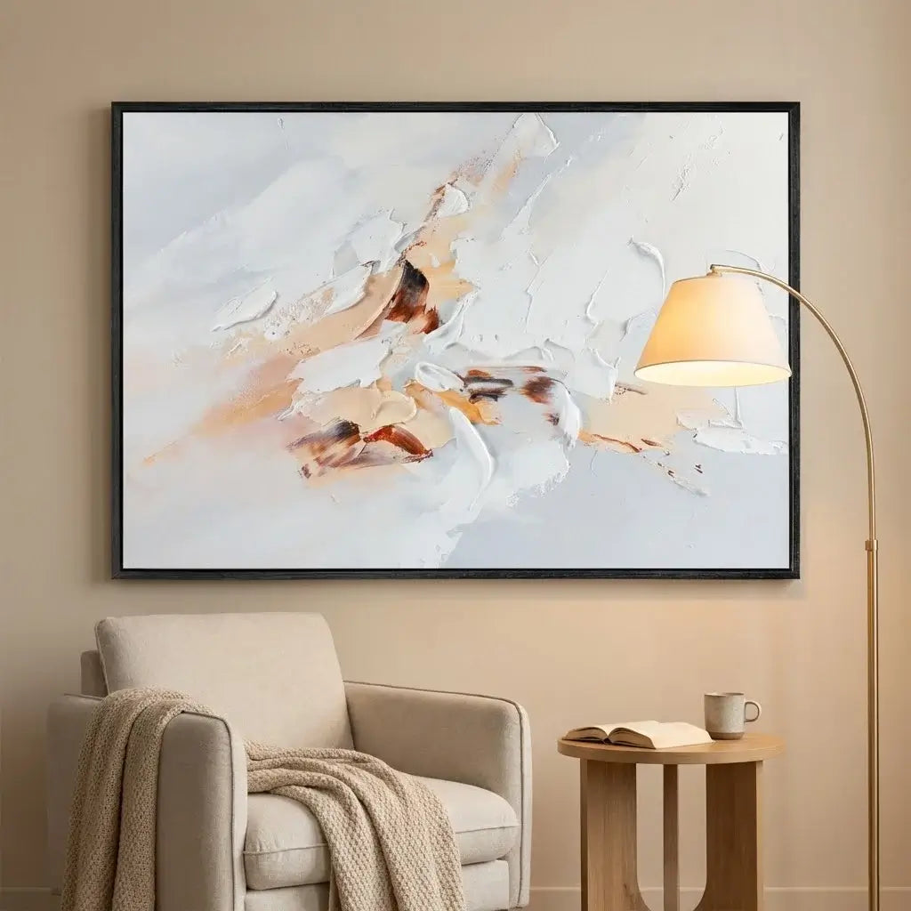 Abstract painting on a wall above a beige armchair with a lamp and small table.
