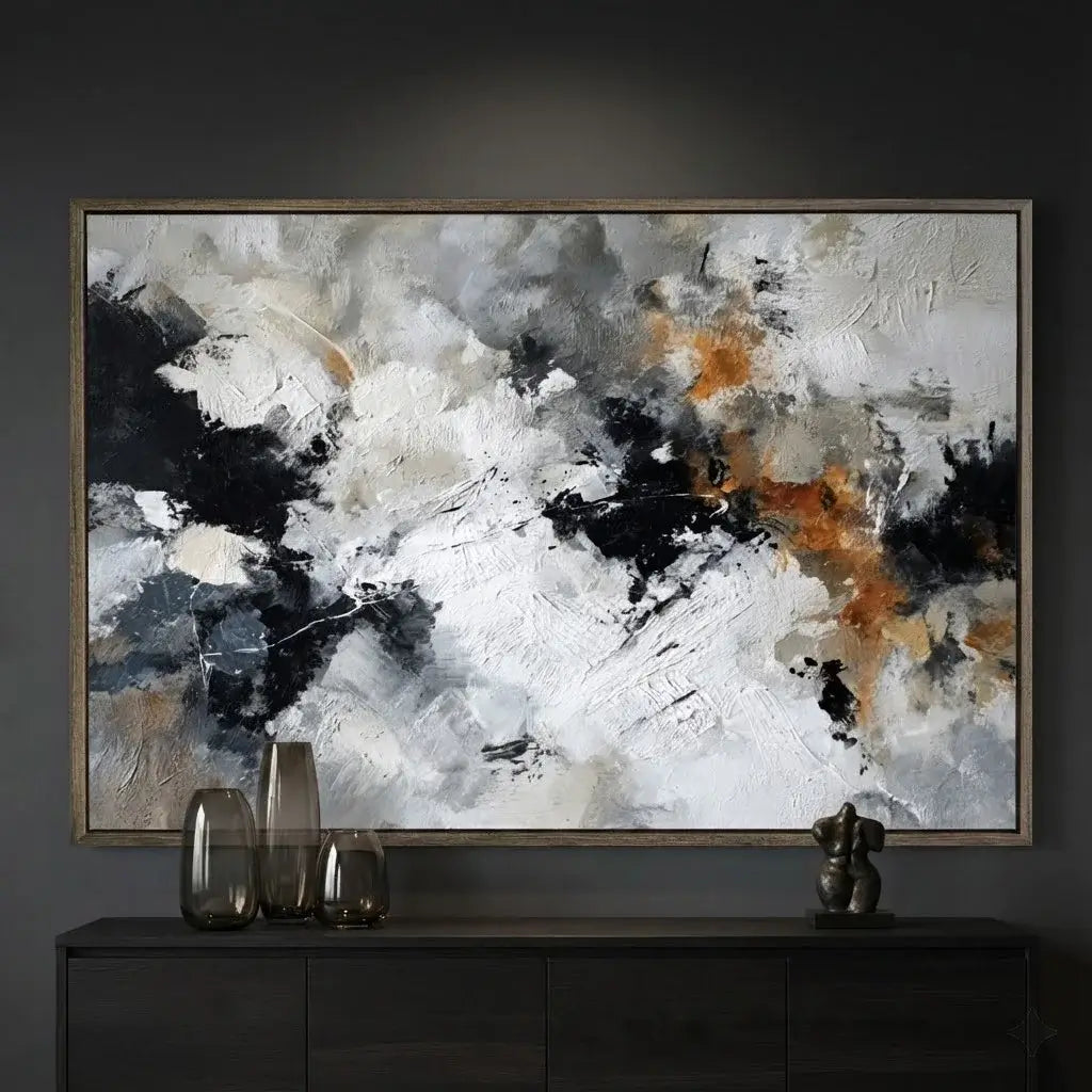 Abstract art painting with black, white, and orange colors on a dark wall.