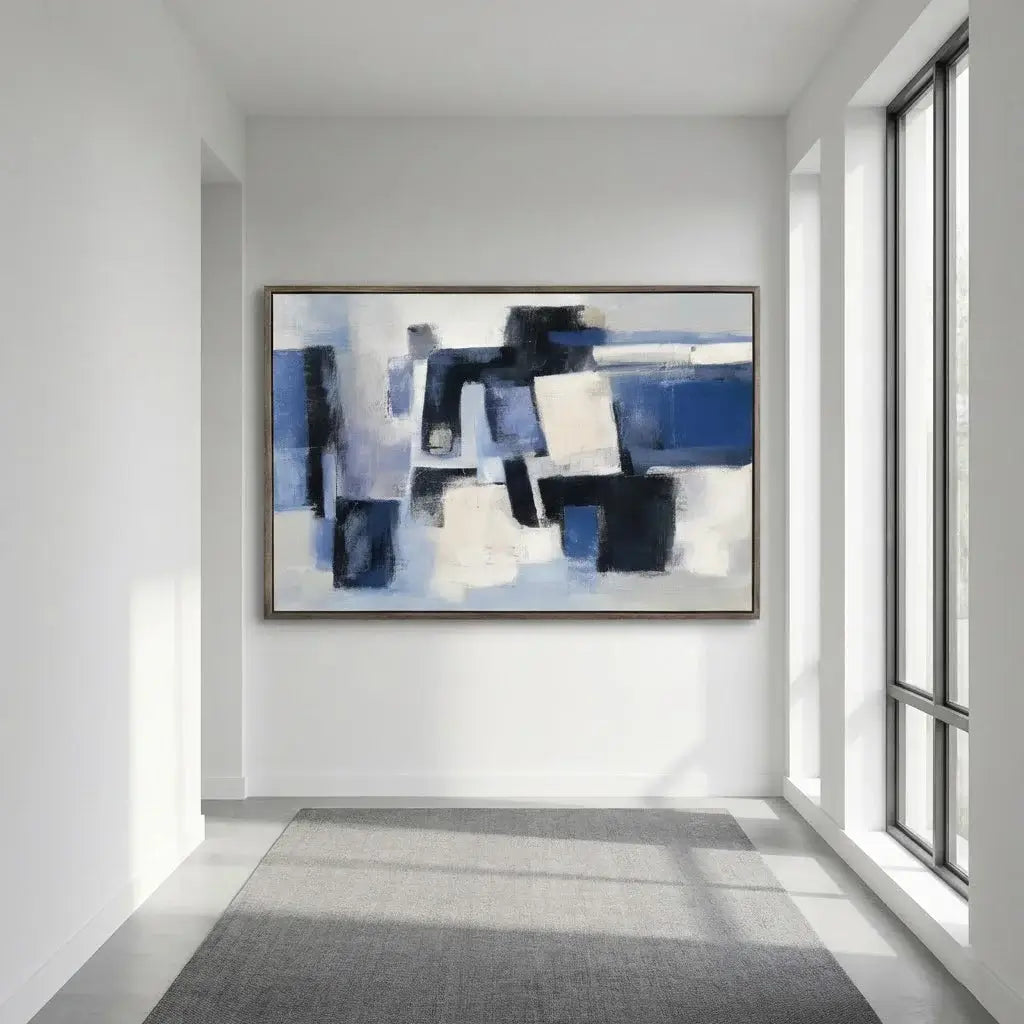 Abstract painting on a wall in a modern room with large windows.