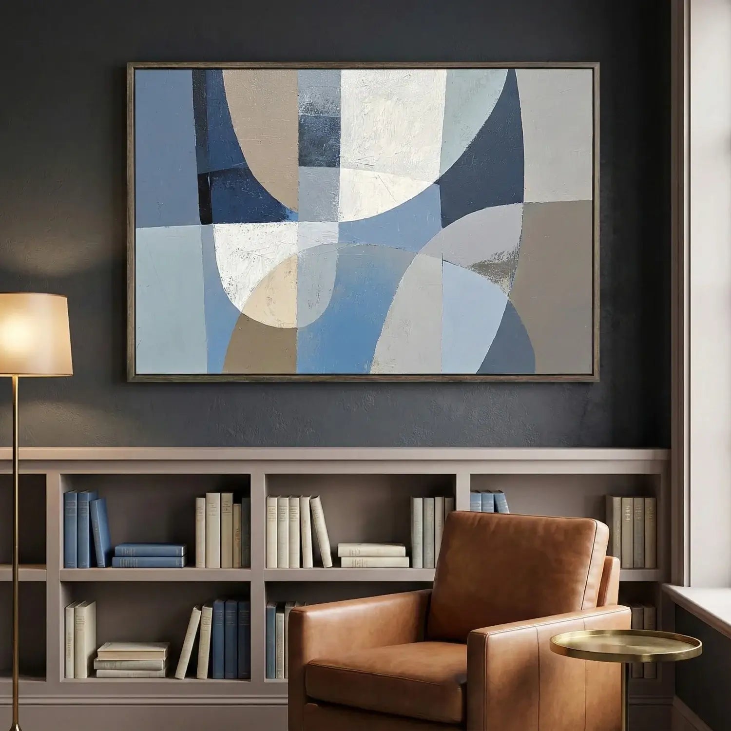 Modern interior with abstract art, bookshelf, and brown armchair.