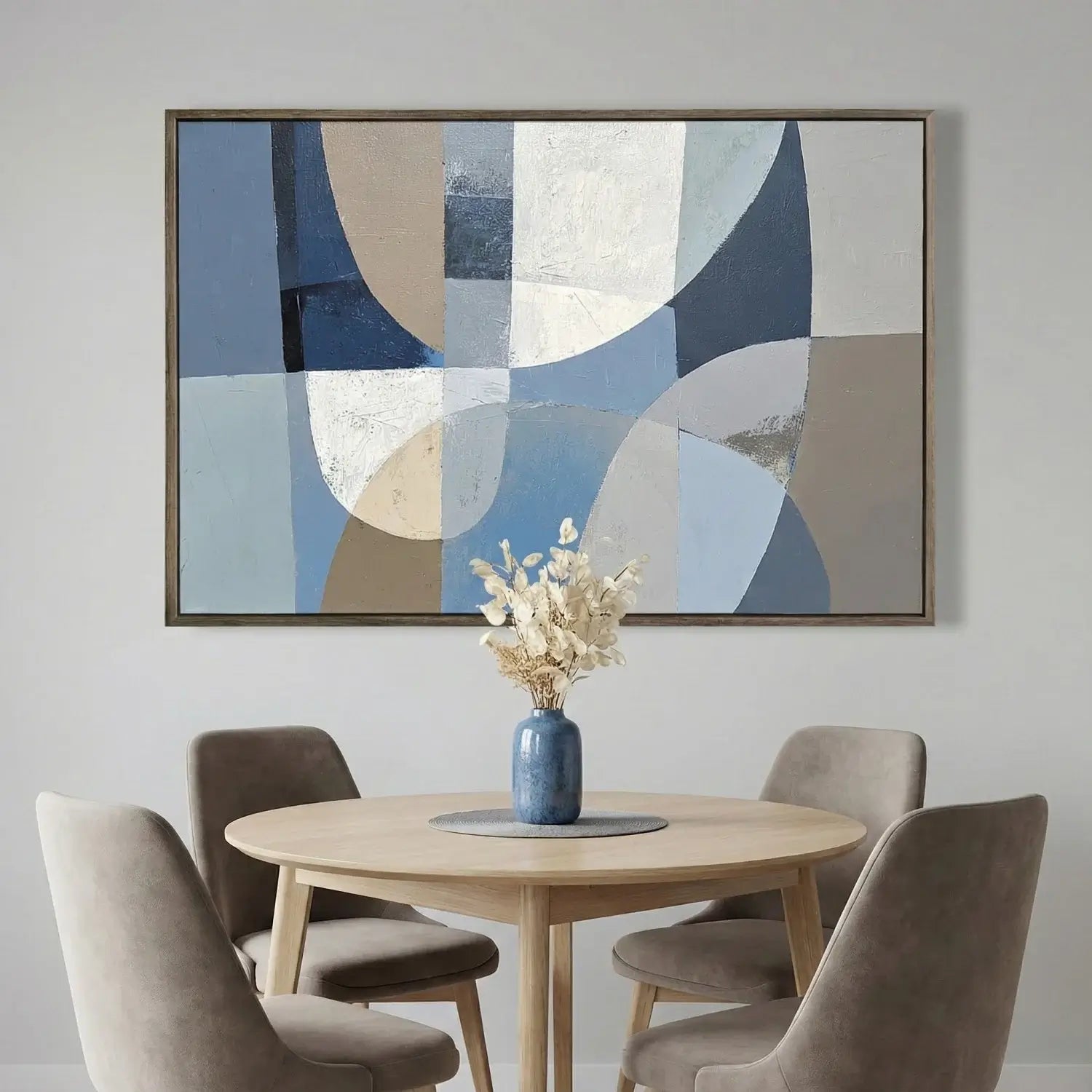 Dining room with abstract art above a round table and chairs.