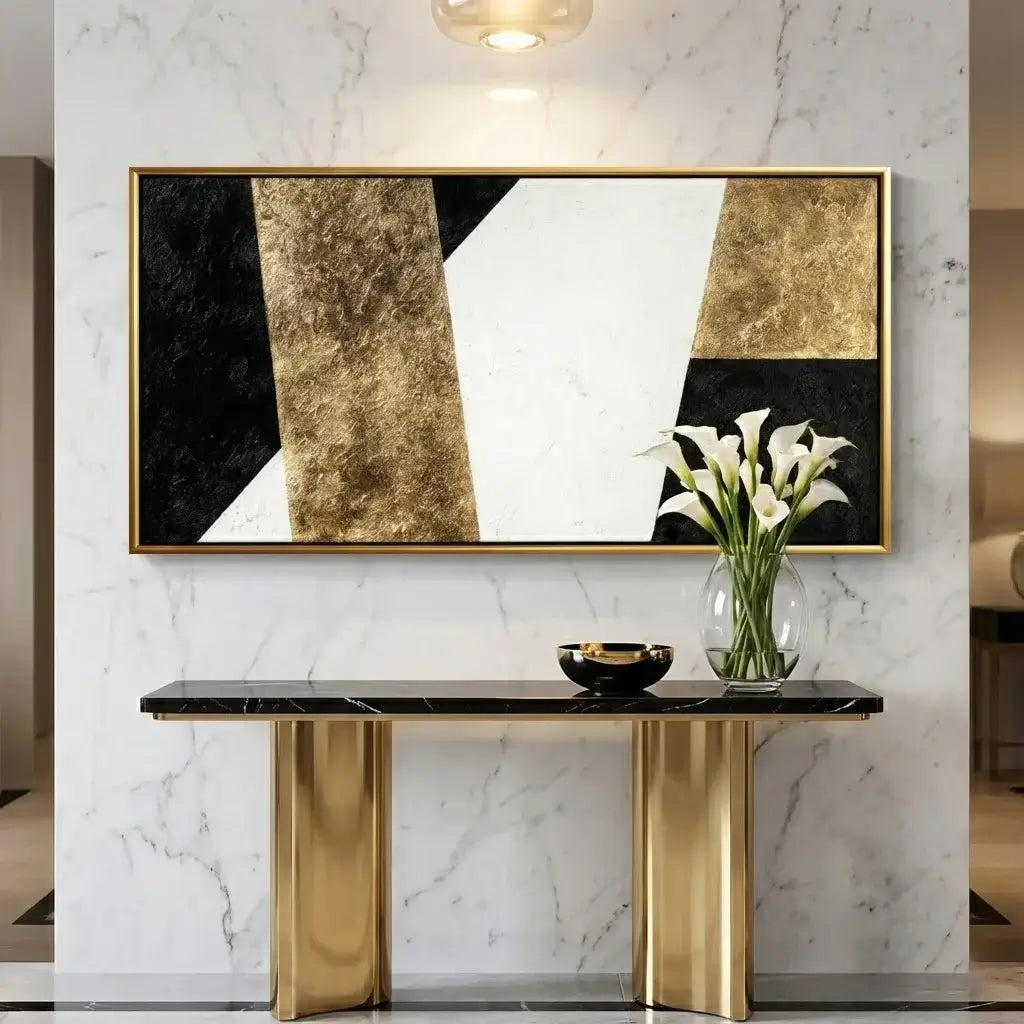 Modern interior with a gold console table, abstract art, and a vase of flowers.