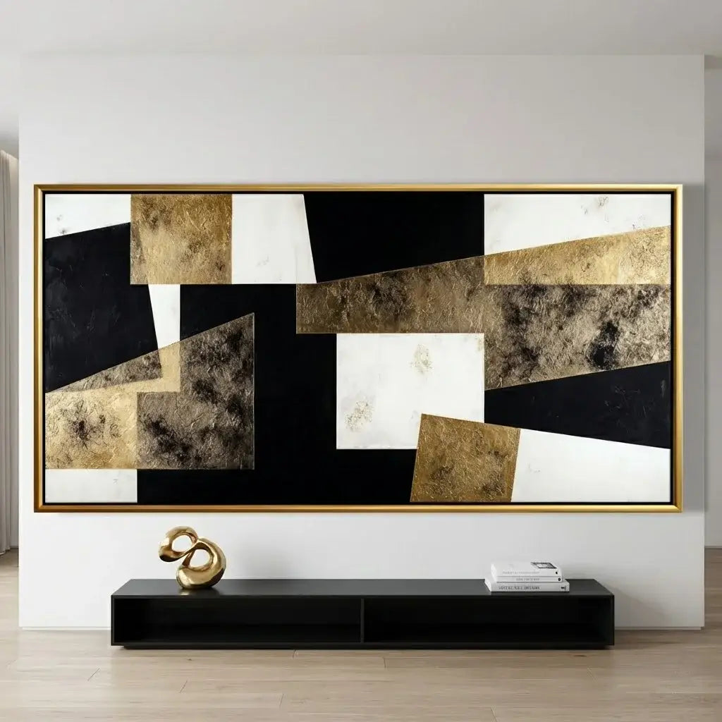 Abstract art piece with gold and black colors on a white wall above a black console table.