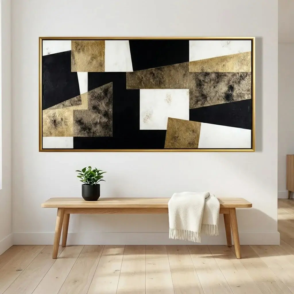 Abstract art piece on a wall above a wooden bench with a plant and blanket.