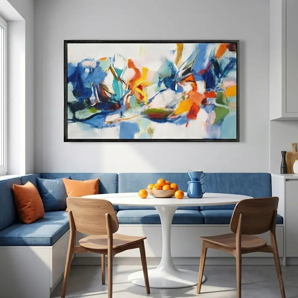 Modern kitchen with blue bench, white table, wooden chairs, and abstract art on the wall.