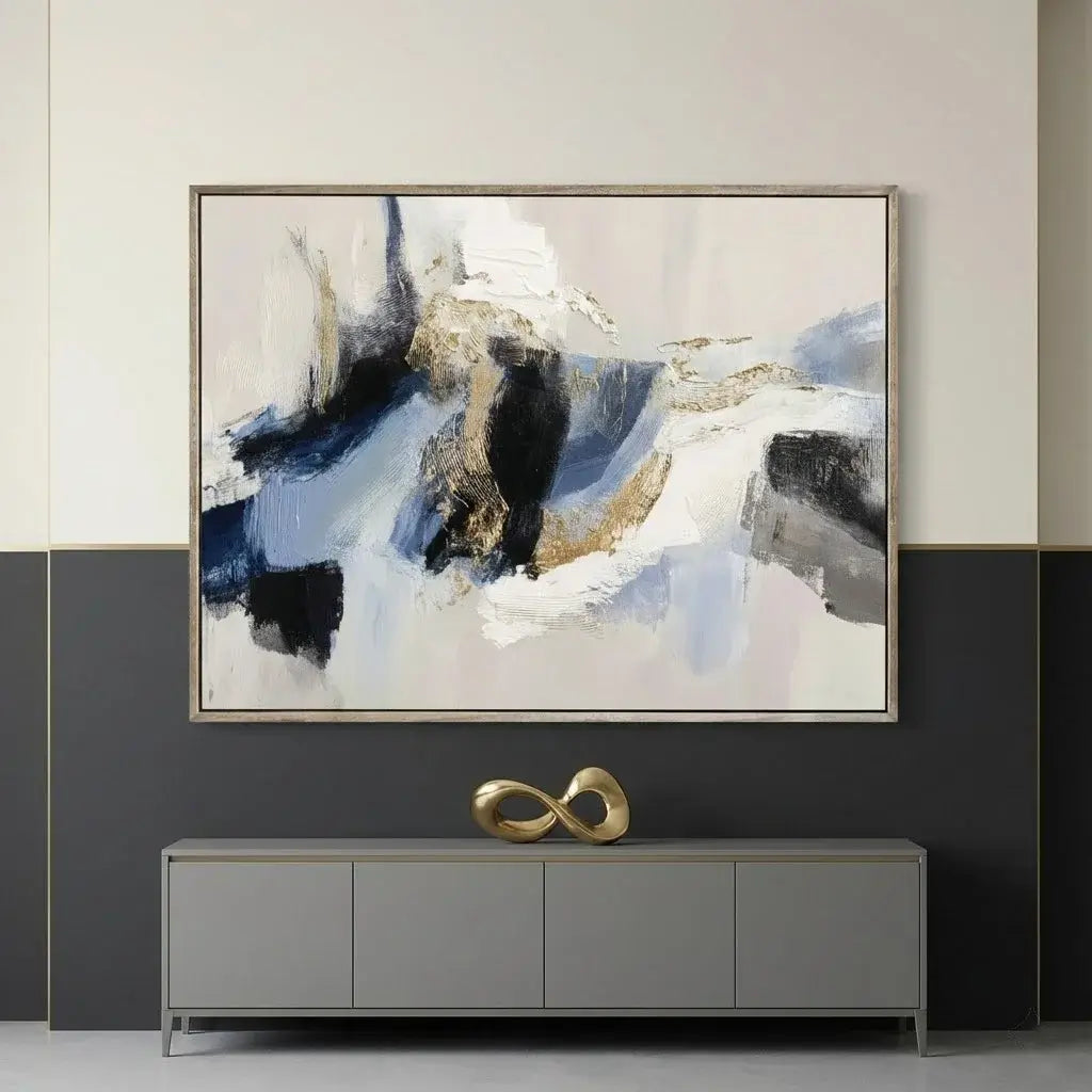 Abstract painting on a wall above a gray console table with a gold decorative piece.