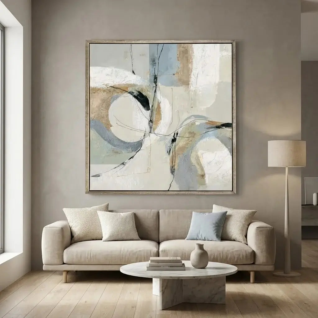 Living room with a beige sofa, abstract painting, and round coffee table.