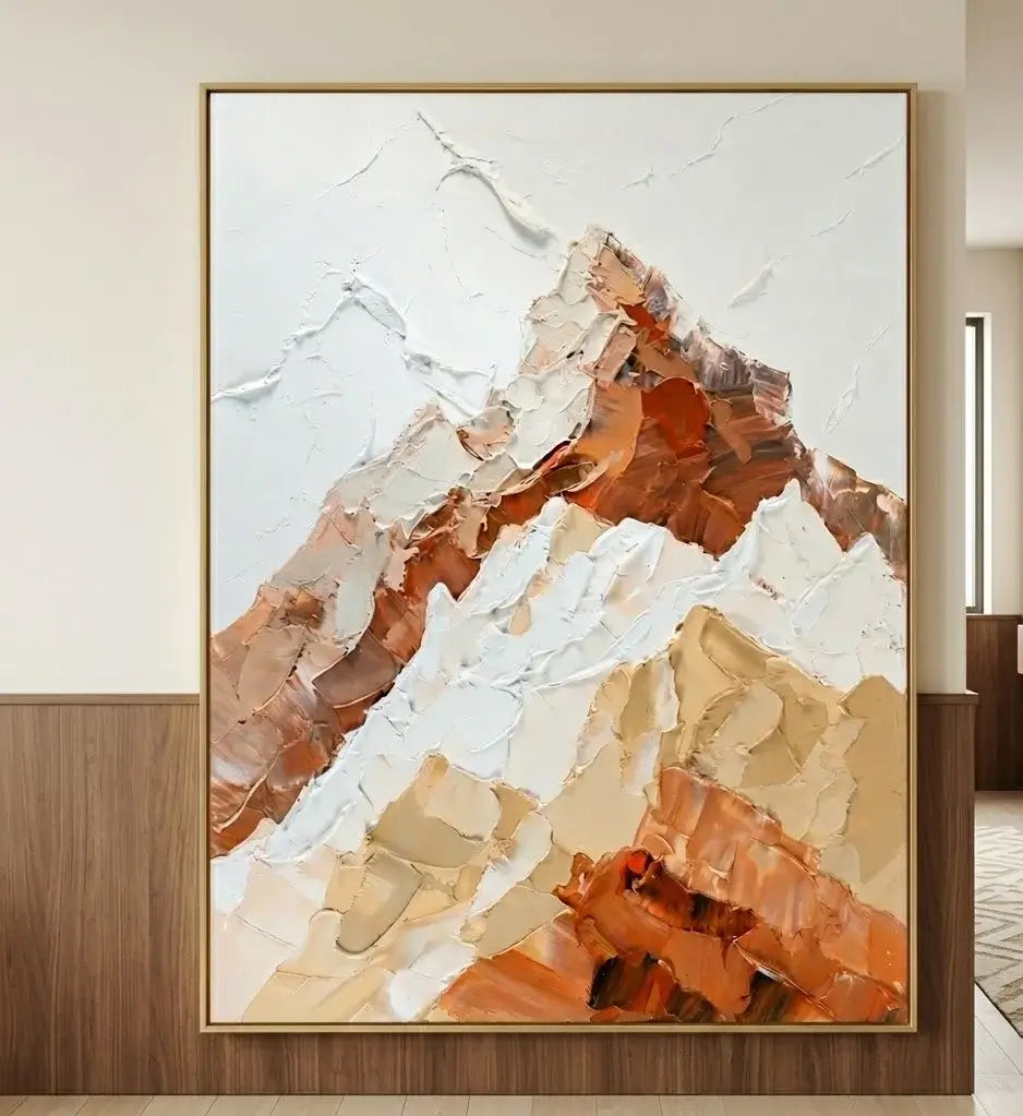 Abstract mountain painting on a wall with a cactus and wooden bench below.