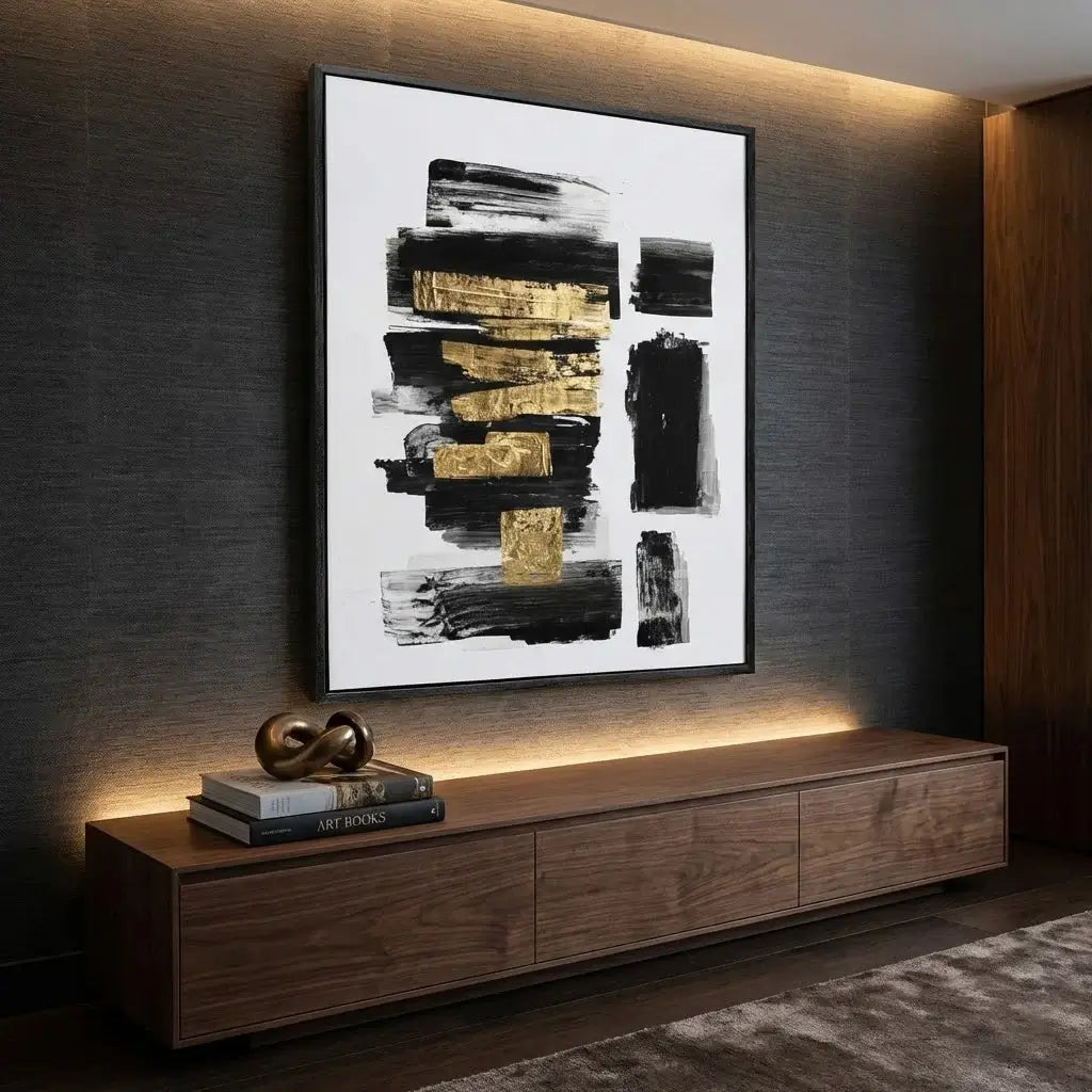 Abstract art piece on a wall above a wooden console table with decor items.