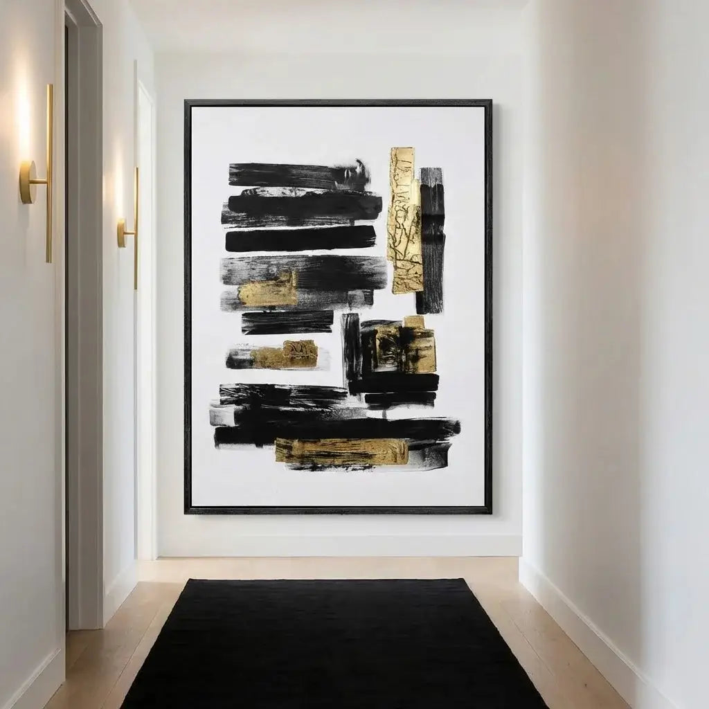 Abstract art piece with black and gold brush strokes in a modern interior setting.