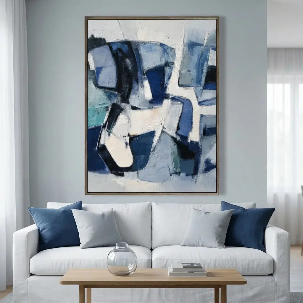 Abstract art piece in a living room with a white sofa and wooden coffee table.