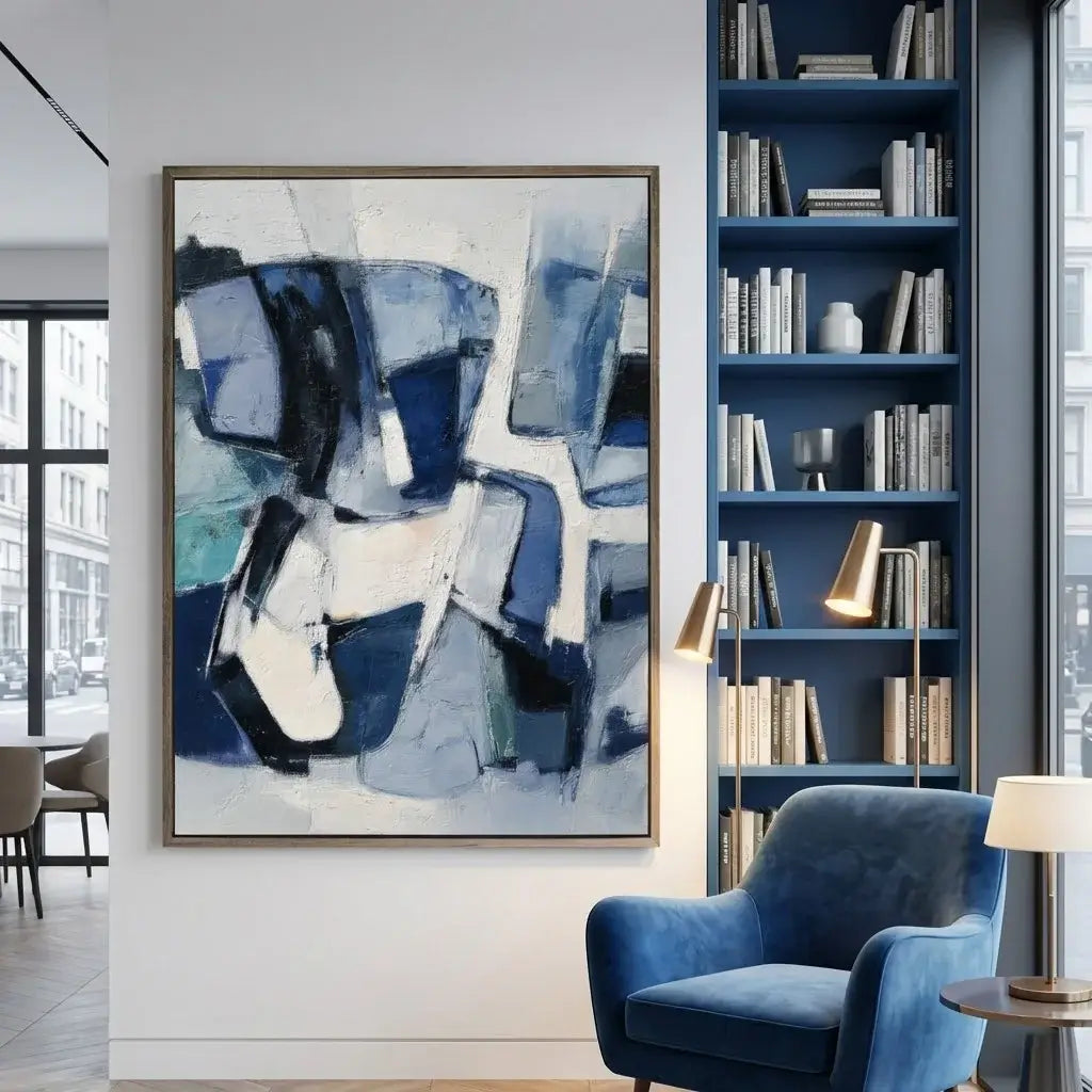 Modern interior with abstract blue and white painting, blue armchair, and bookshelf.